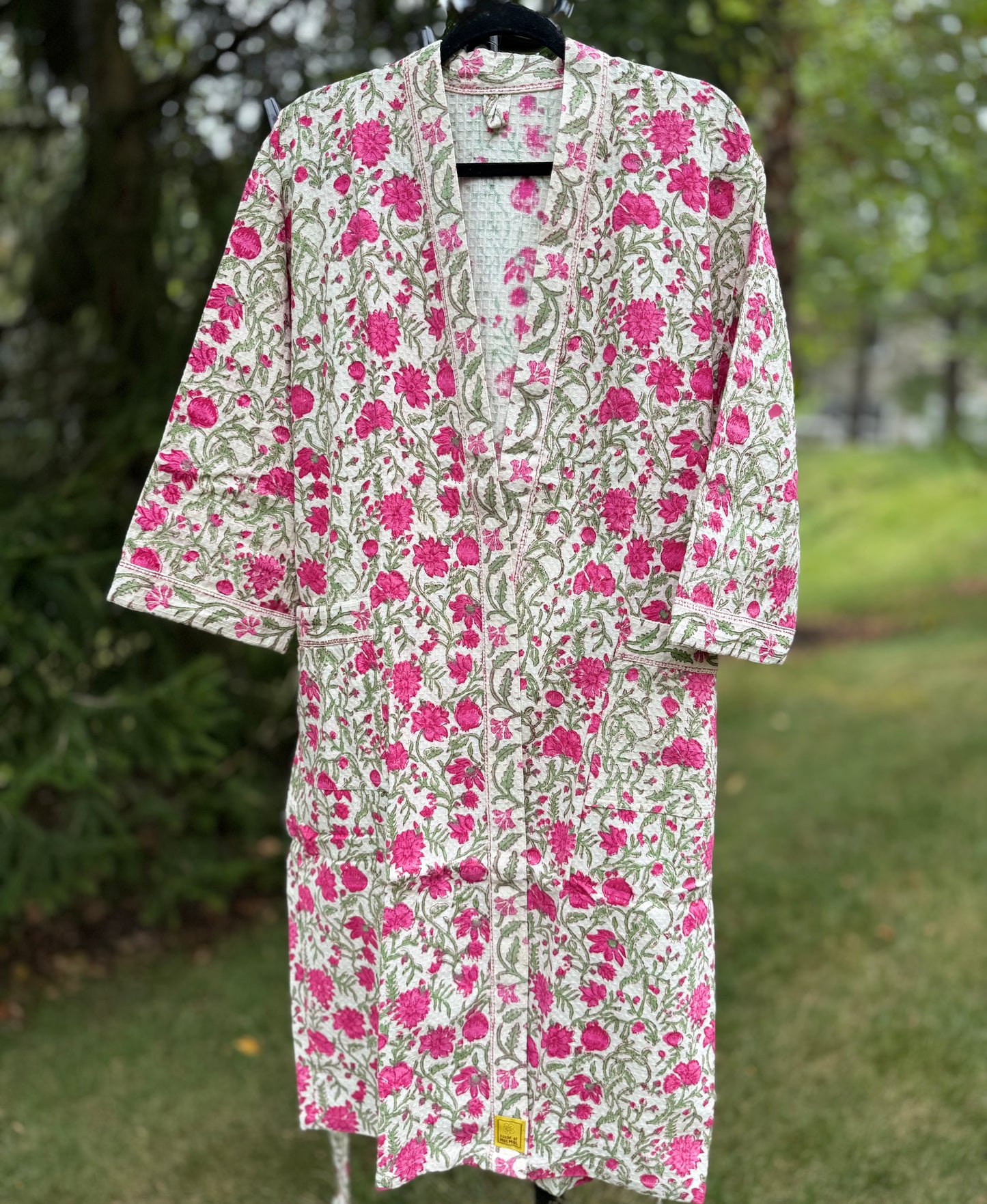 House of Mulmul - cotton bath robe. Floral patterned robe with pink flowers on a green background.
