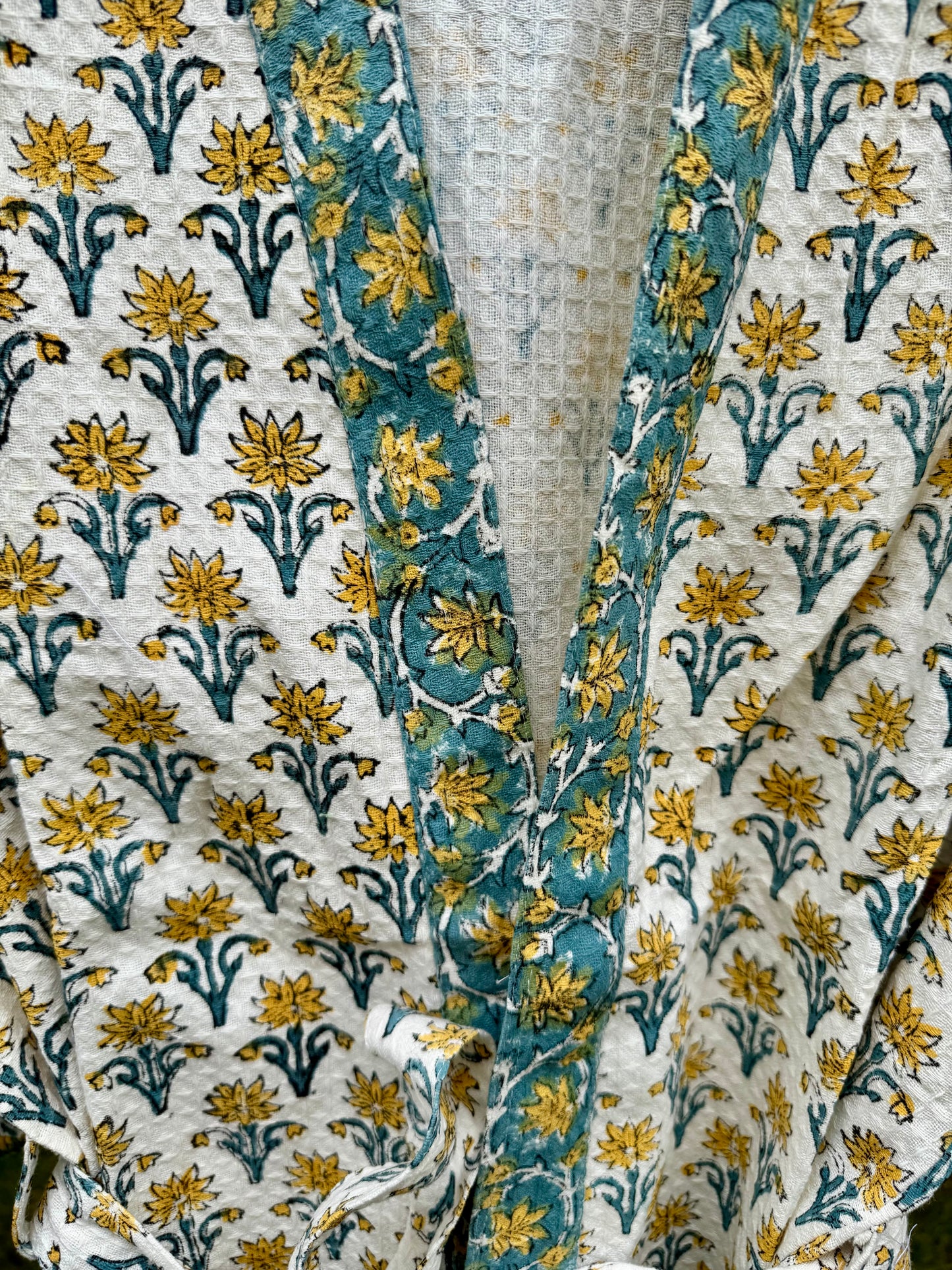 House of Mulmul - cotton bath robe. Close-up of floral patterned fabric with blue and yellow colors.