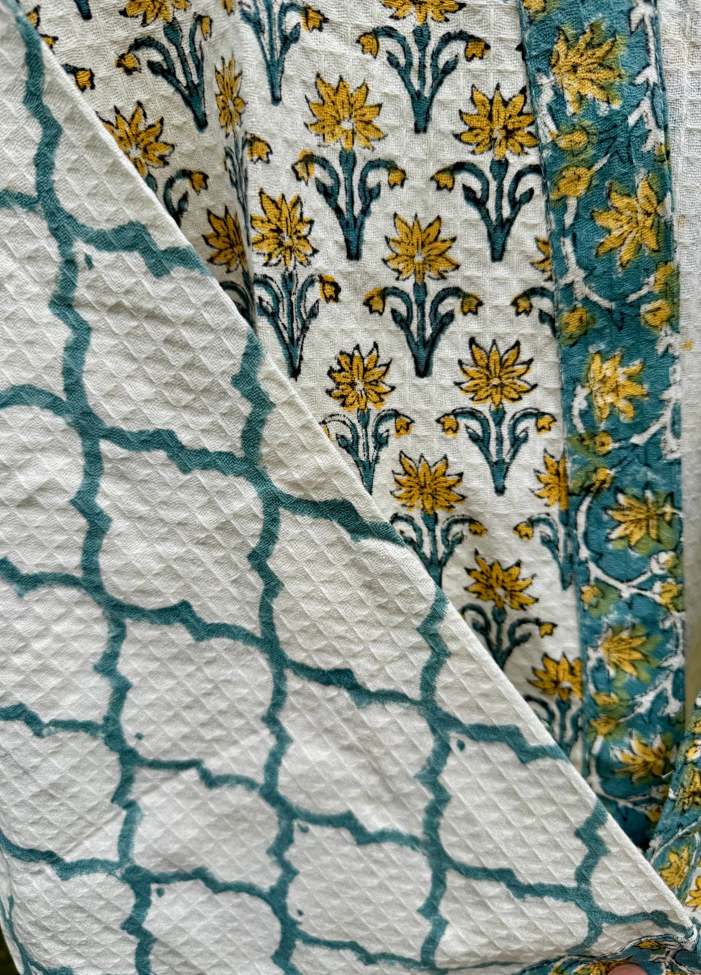House of Mulmul - cotton bath robe. Close-up of fabric with floral and geometric patterns.