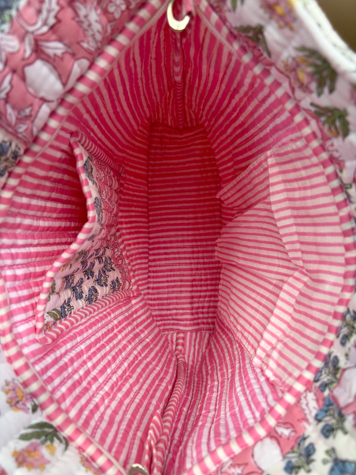 House of Mulmul - Bucket Tapered Tote Bag. Close-up of a pink and white striped fabric lining inside a floral-patterned tote bag, with a small metal zipper visible at the top.