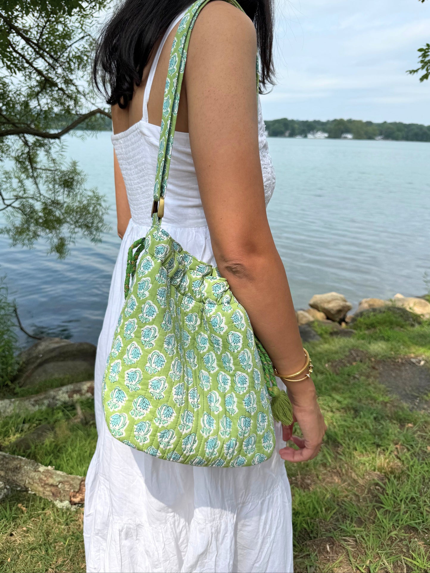 Woman with a green patterned bag by a lakeside