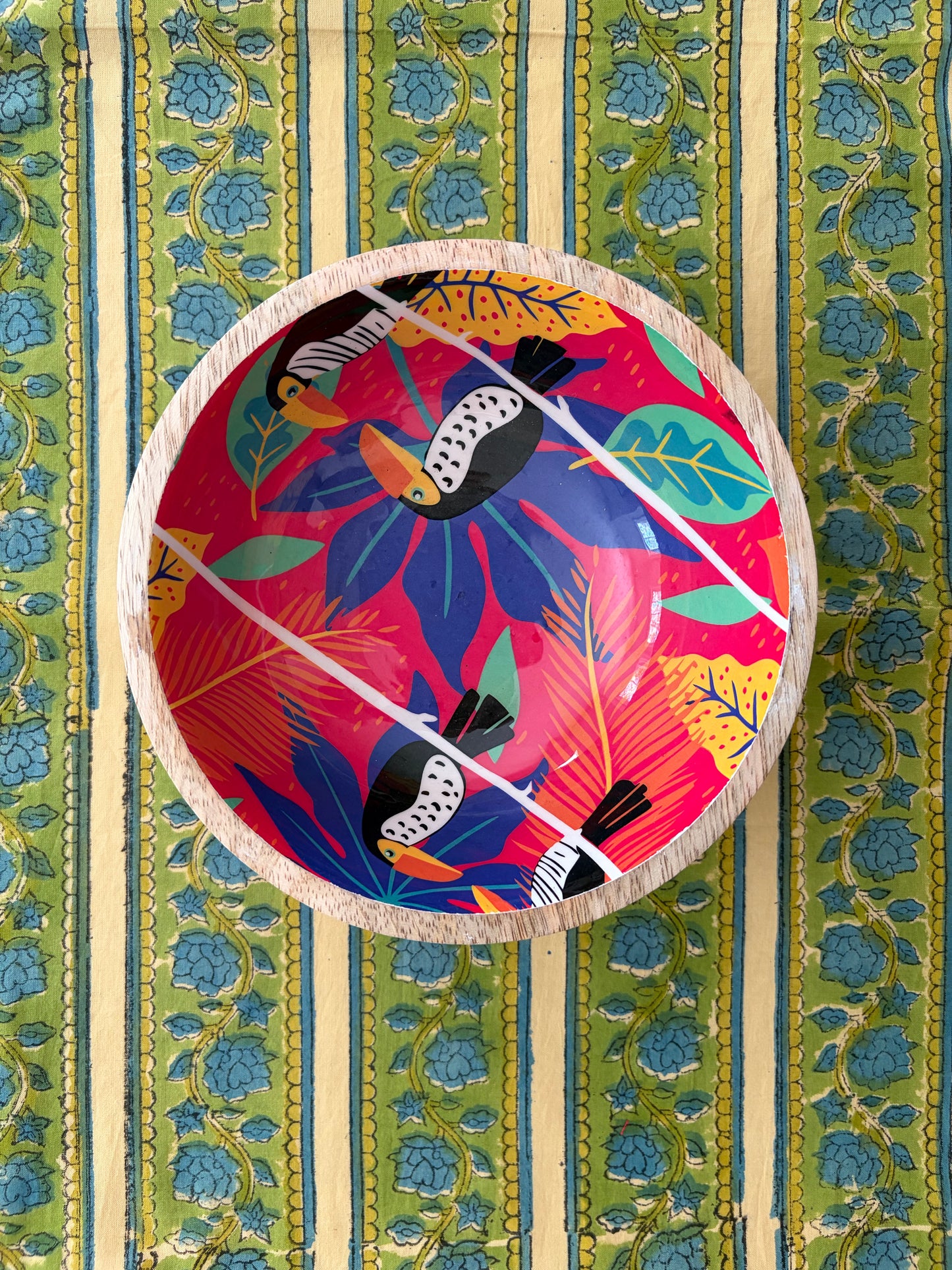 House of Mulmul - Blockprinted Cotton Reversible Table Runner & Mats set. Decorative plate with colorful bird design on a patterned fabric background