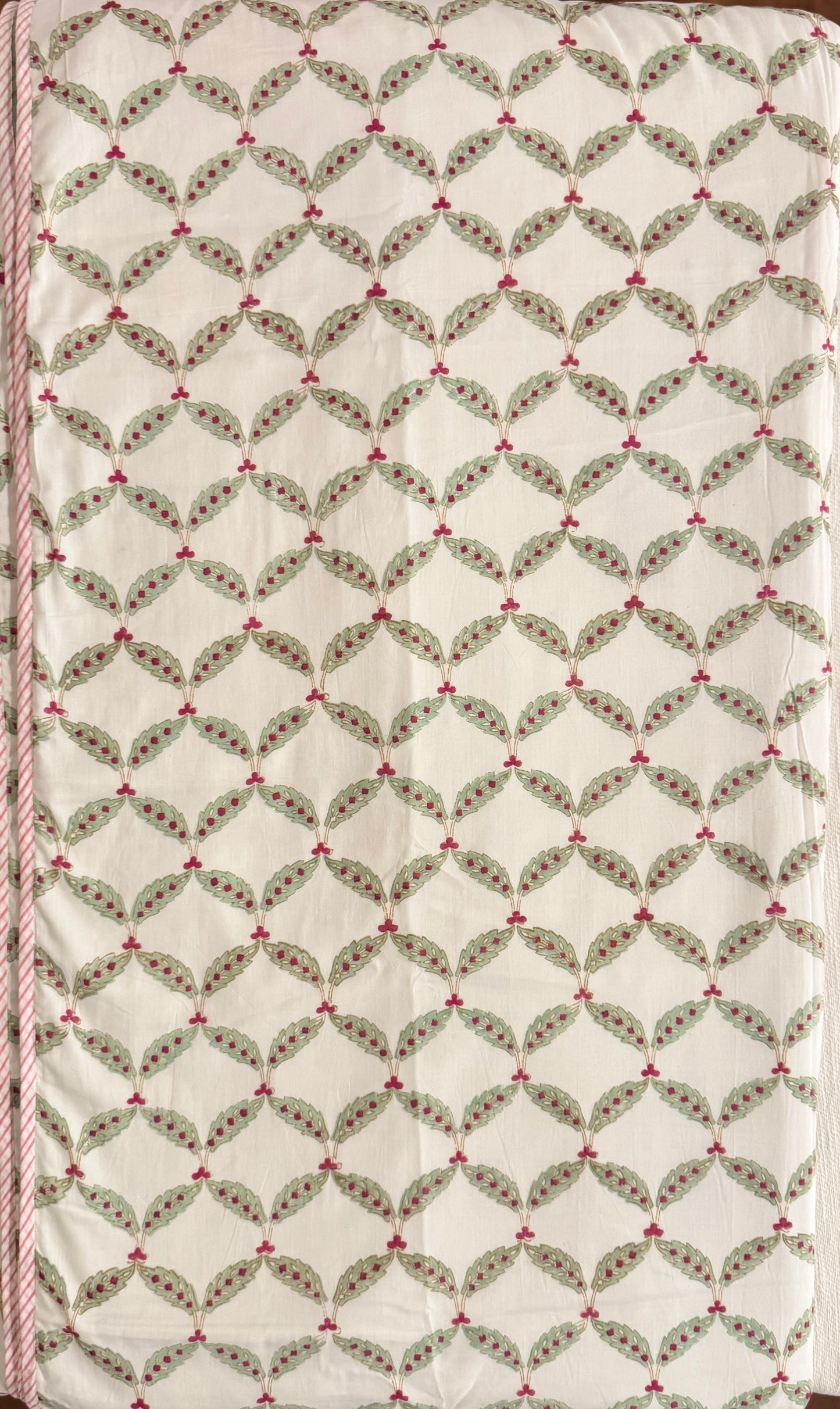 House of Mulmul - Coverlet Dohar, cotton blanket, muslin blanket, mulmul dohar. Decorative handblock printed fabric with patterned fabric with green leaves and red berries on a white background