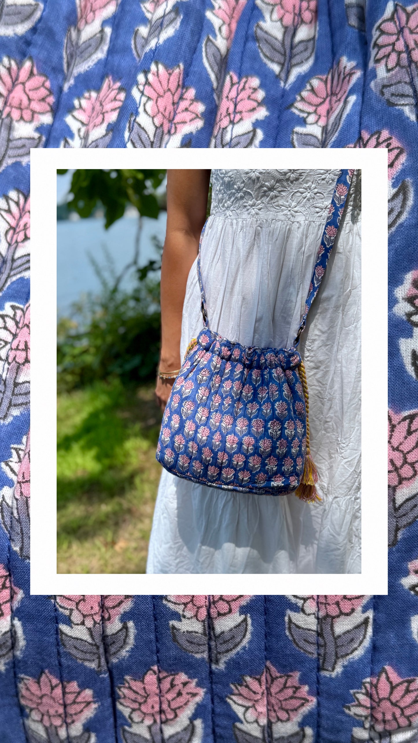 House of Mulmul - Garden Wayfarer Bucket Bag, Cotton bag, Crossbody sling bag. Person wearing a white dress with a blue floral-patterned bag outdoors.