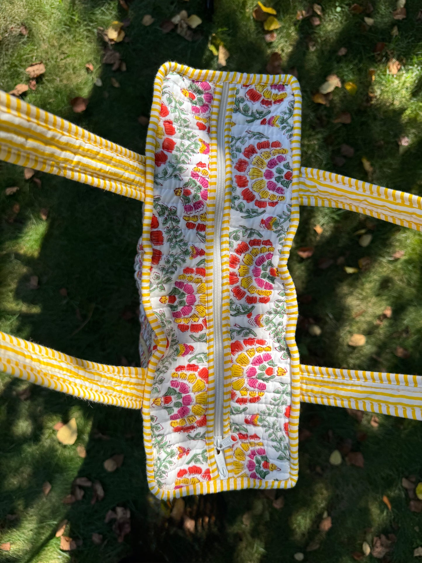 House of Mulmul - Cotton Tote Bag. Floral-patterned pouch with a zipper on a grassy background