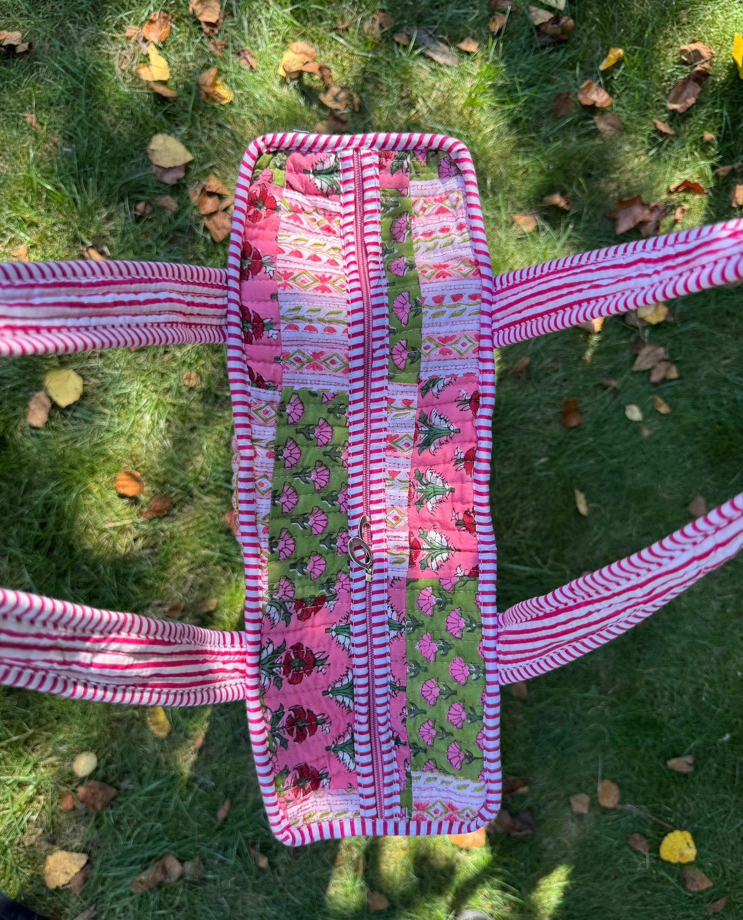 House of Mulmul - Cotton Tote Bag. Pink and green patterned belt on grass