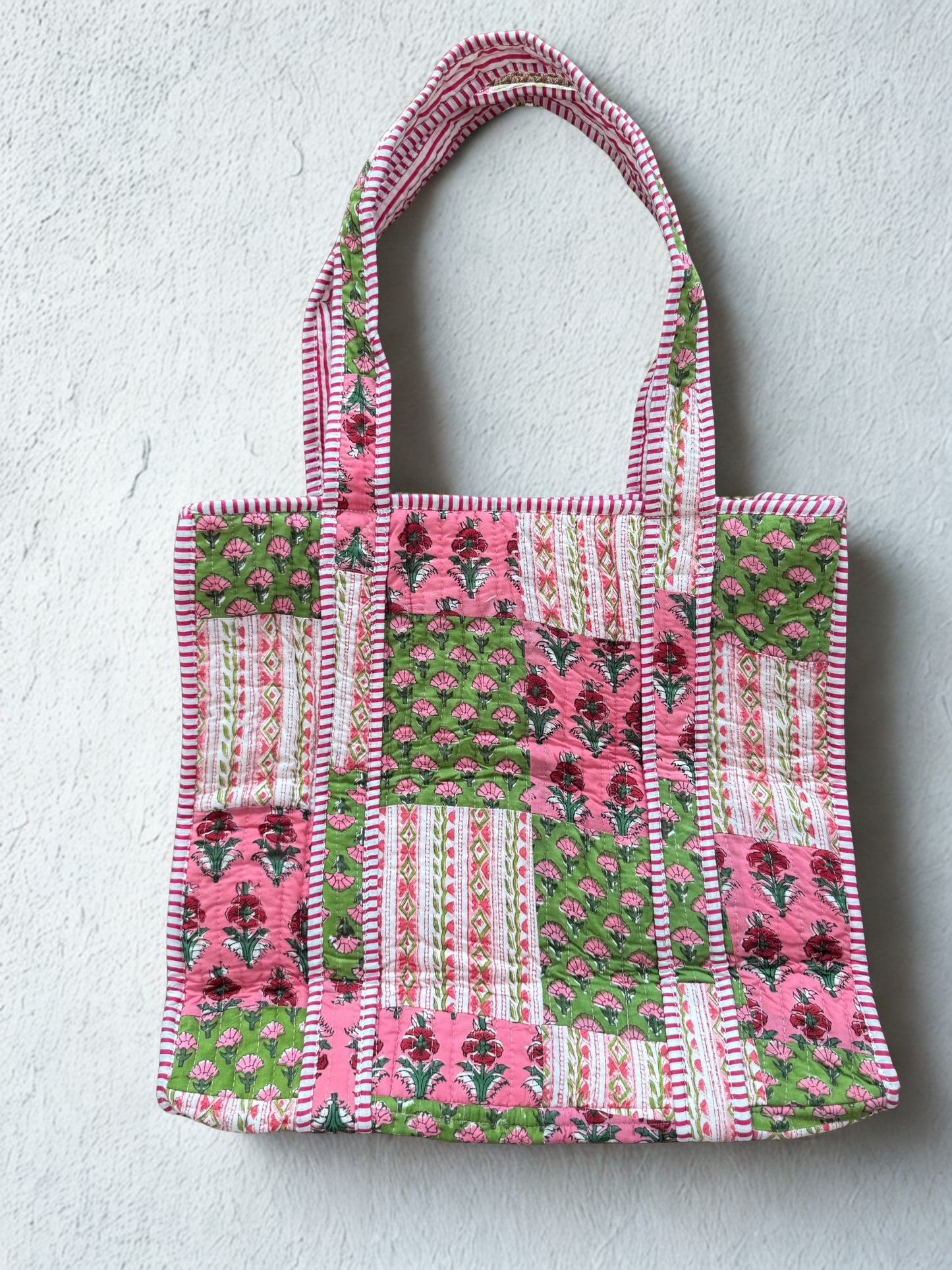 House of Mulmul - Cotton Tote Bag. Patchwork tote bag with pink and green patterns on a light gray background