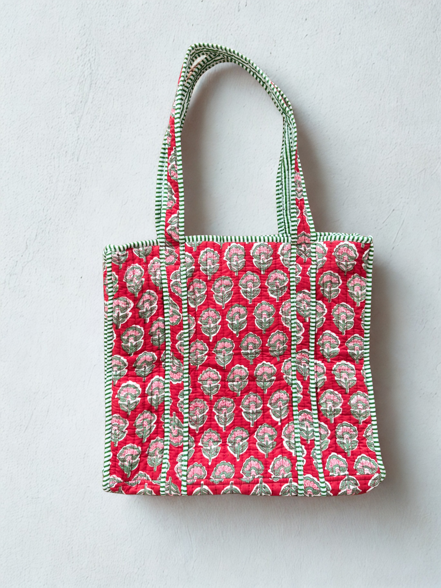 House of Mulmul - Cotton Tote Bag. Tote bag with red pink floral pattern and green trim on a light gray background