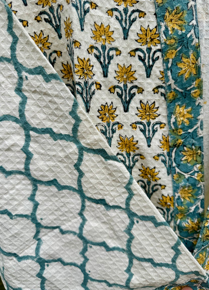 House of Mulmul - cotton bath robe. Close-up of fabric with floral and geometric patterns.