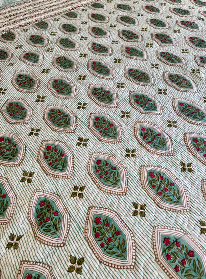 House of Mulmul - Blockprinted Cotton Bedcover. Reversible Bedspread. Close-up of a patterned fabric with geometric shapes and floral elements.