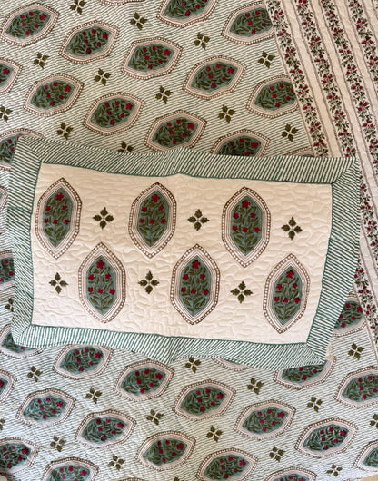 House of Mulmul - Blockprinted Cotton Bedcover. Reversible Bedspread. Bedroom with a floral-patterned quilt on a bed, framed mirror, pillowcases and curtains.