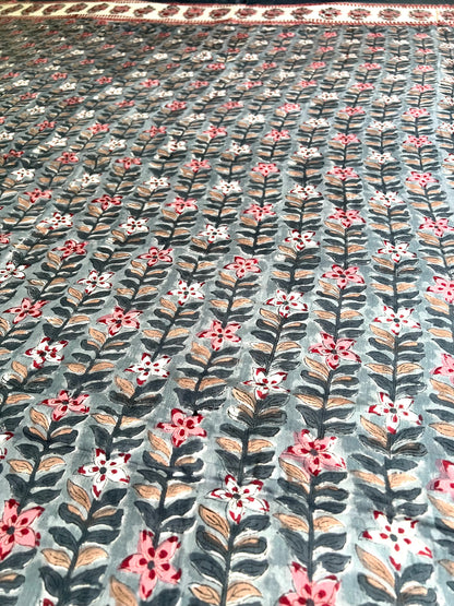 House of Mulmul - Handblock printed cotton summer quilt. Cotton coverlet. Cotton dohar. Muslin blanket. Indian summer quilt. Indian dohar. Floral patterned fabric with pink, white, and green flowers on a gray background