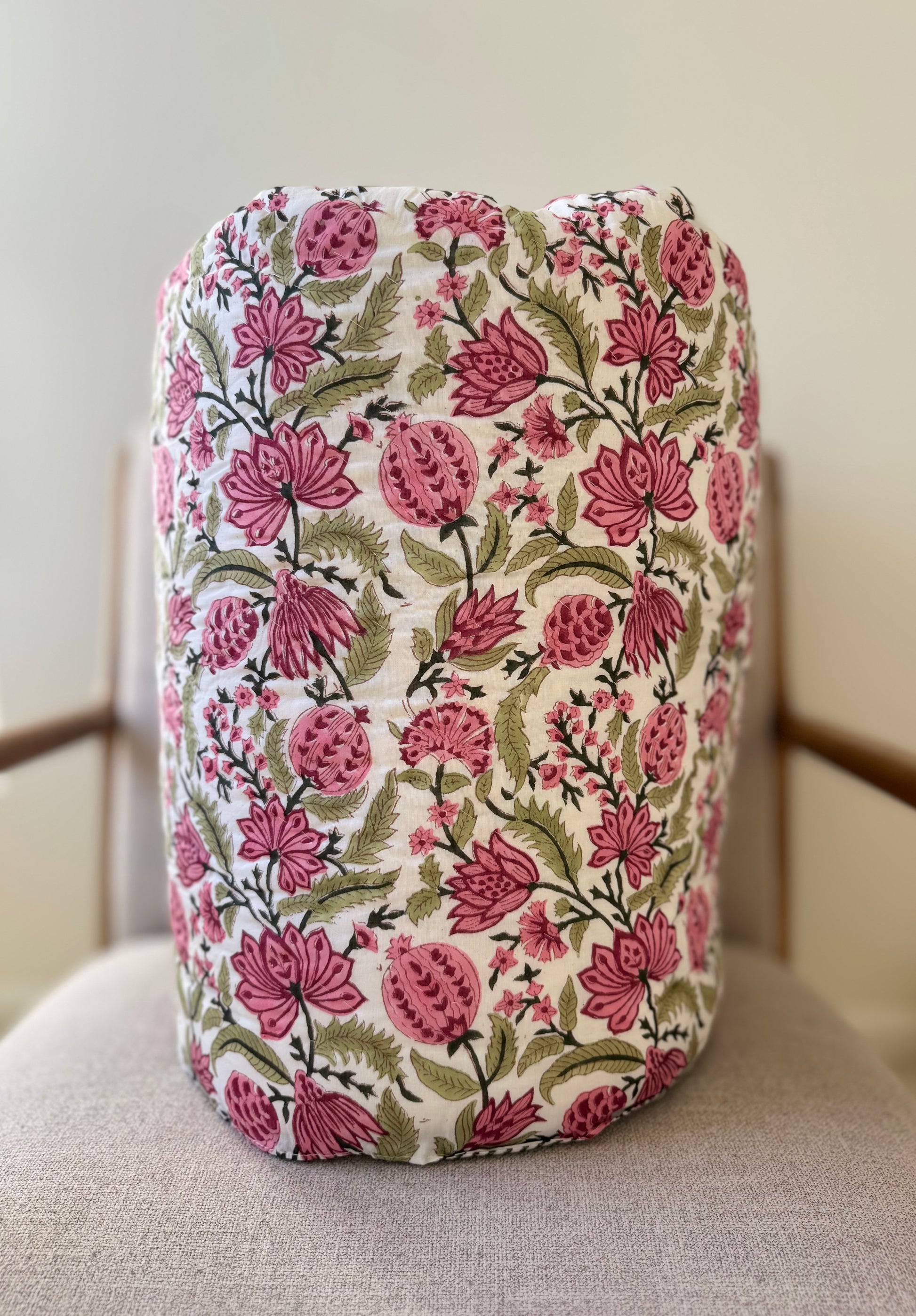 House of Mulmul - Blockprinted Cotton Quilt. Reversible Quilt. Rolled-up quilt with floral and striped patterns.