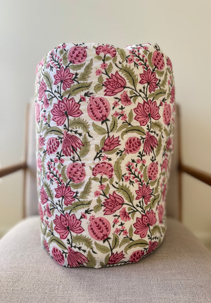 House of Mulmul - Blockprinted Cotton Quilt. Reversible Quilt. Rolled-up quilt with floral and striped patterns.