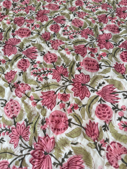 House of Mulmul - Blockprinted Cotton Quilt. Reversible Quilt. Floral patterned fabric with pink flowers and green leaves on a white background