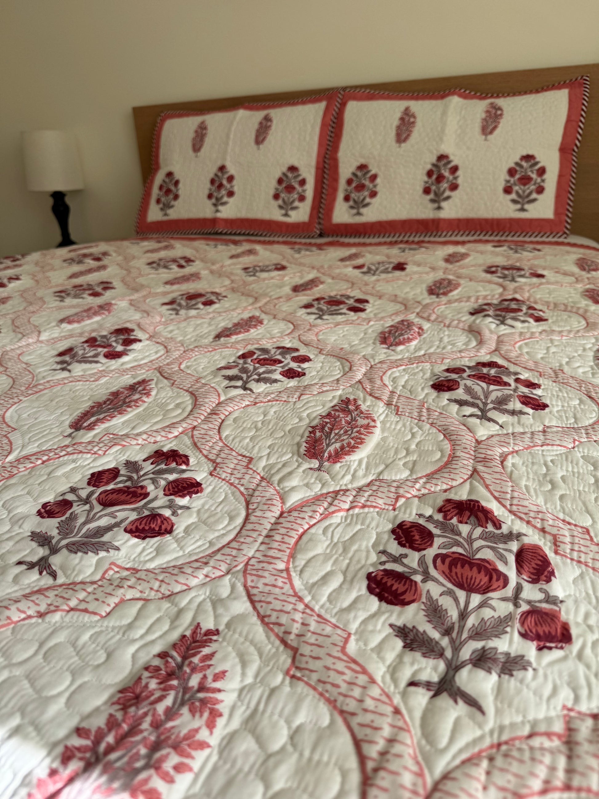 House of Mulmul - Blockprinted Cotton Bedcover Reversible Muslin. Bedcover with red floral pattern on a bed in a room setting