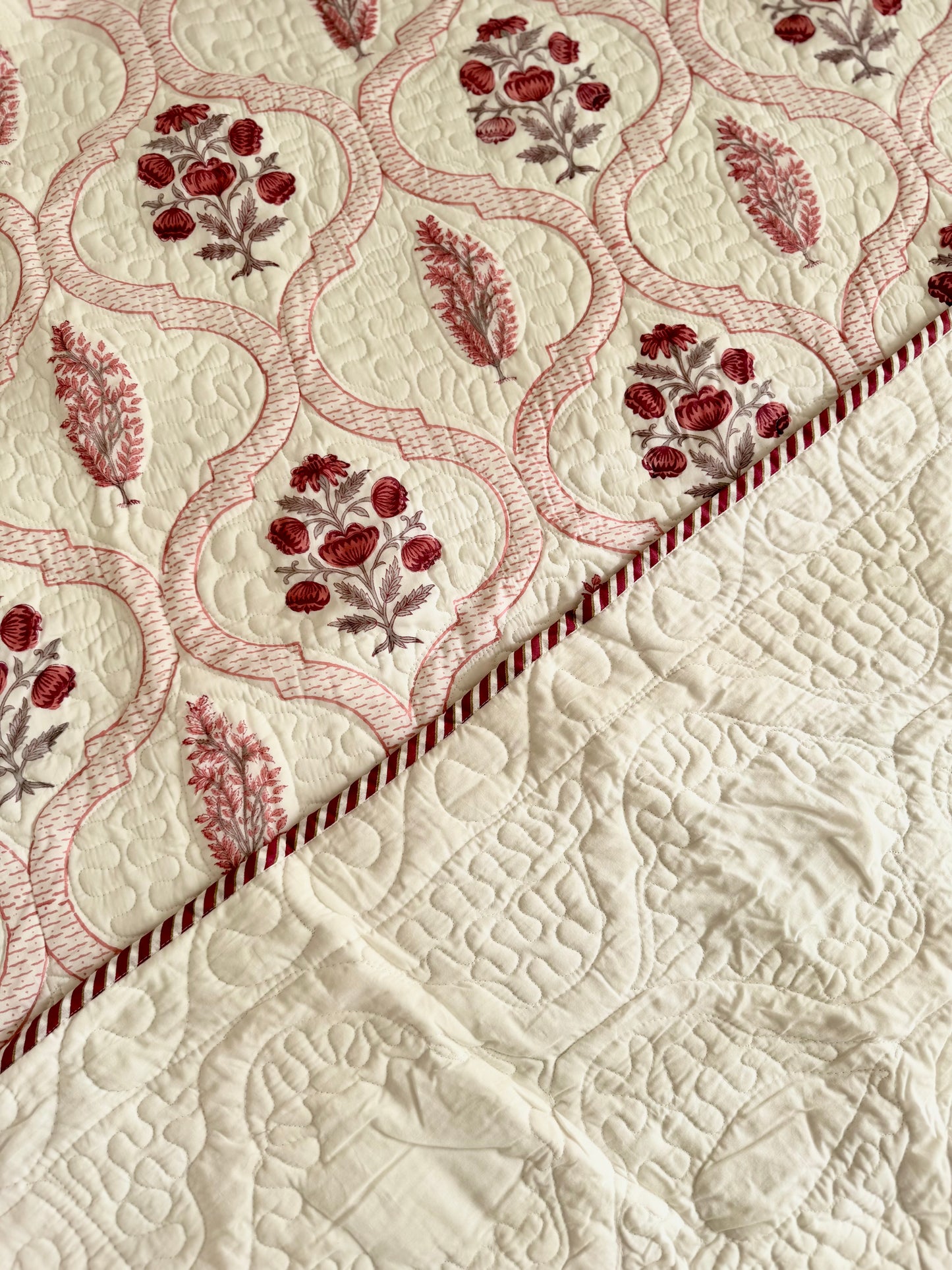House of Mulmul - Blockprinted Cotton Bedcover Reversible Muslin. Close-up of a bedspread with floral embroidery on a beige background