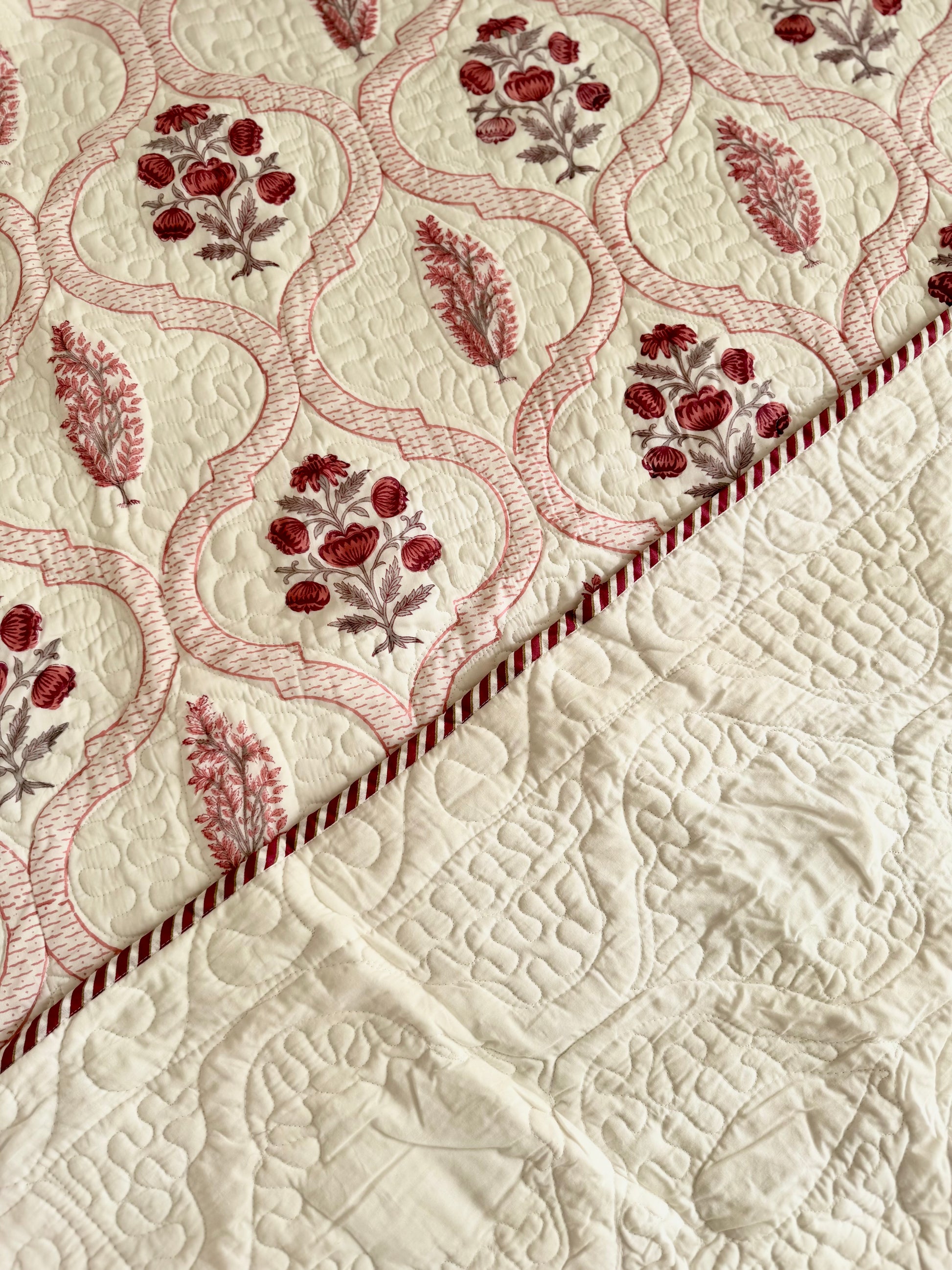 House of Mulmul - Blockprinted Cotton Bedcover Reversible Muslin. Close-up of a bedspread with floral embroidery on a beige background