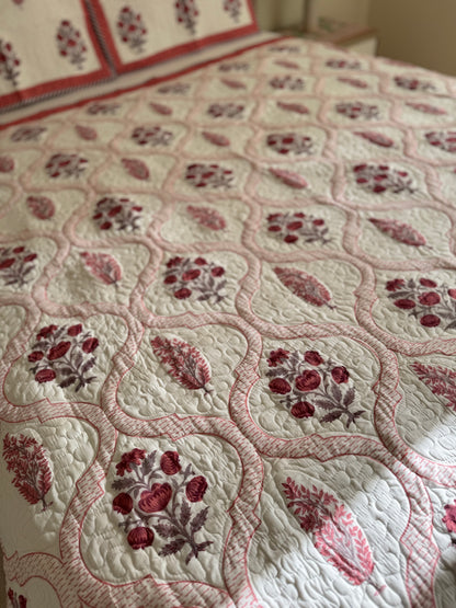 House of Mulmul - Blockprinted Cotton Bedcover Reversible Muslin. Floral patterned bedspread with red and brown designs on a bed.