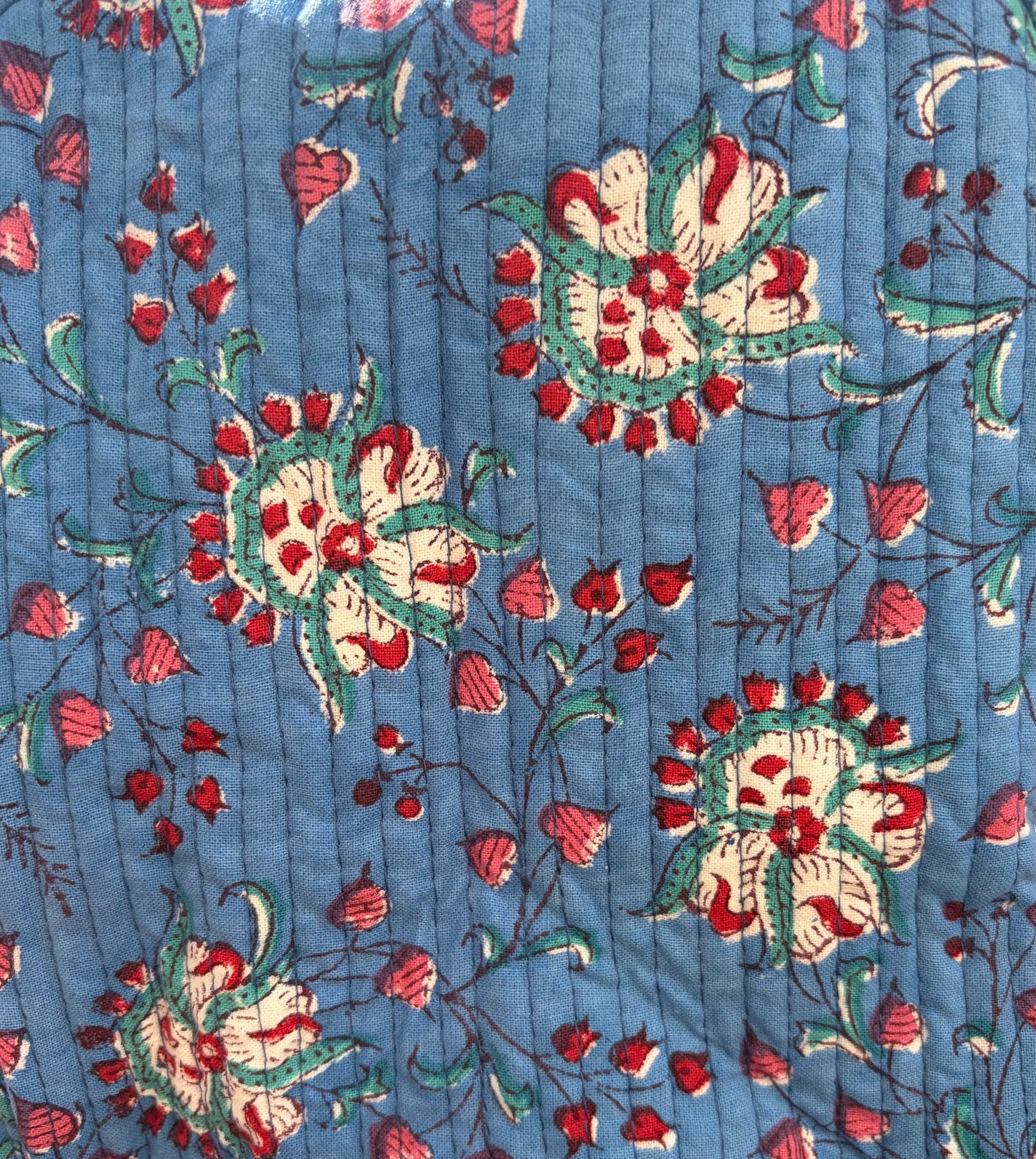 House of Mulmul - Blockprinted Cotton Duffle Bag Weekender Bag. Close-up of floral patterned fabric with red, green, and white flowers on a blue background