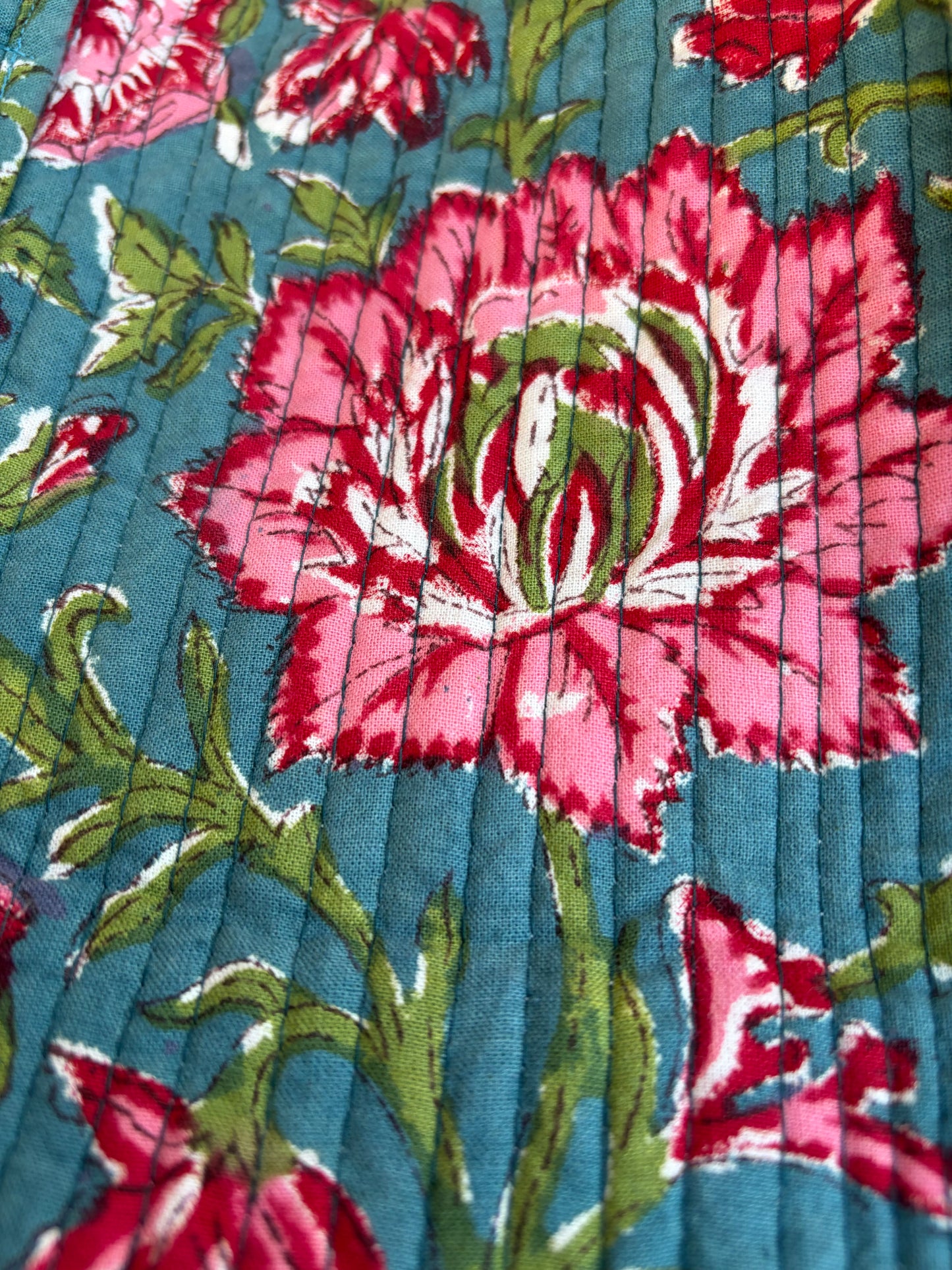 House of Mulmul - Blockprinted Cotton Duffle Bag Weekender Bag. Close-up of a floral fabric pattern with pink flowers on a blue background