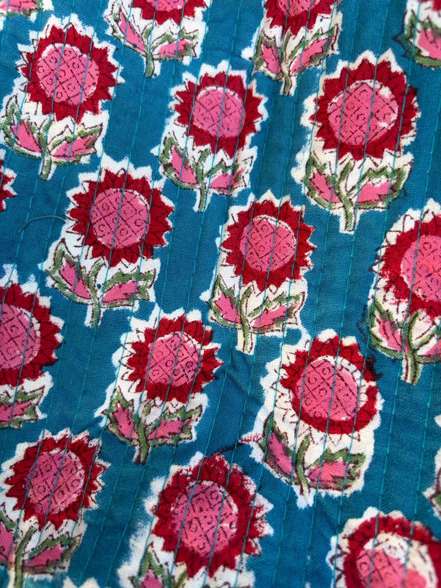 House of Mulmul - Blockprinted Cotton Duffle Bag Weekender Bag. Close-up of a fabric with red and pink floral pattern on a blue background