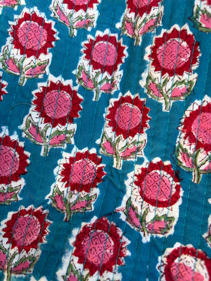 House of Mulmul - Blockprinted Cotton Duffle Bag Weekender Bag. Close-up of a fabric with red and pink floral pattern on a blue background
