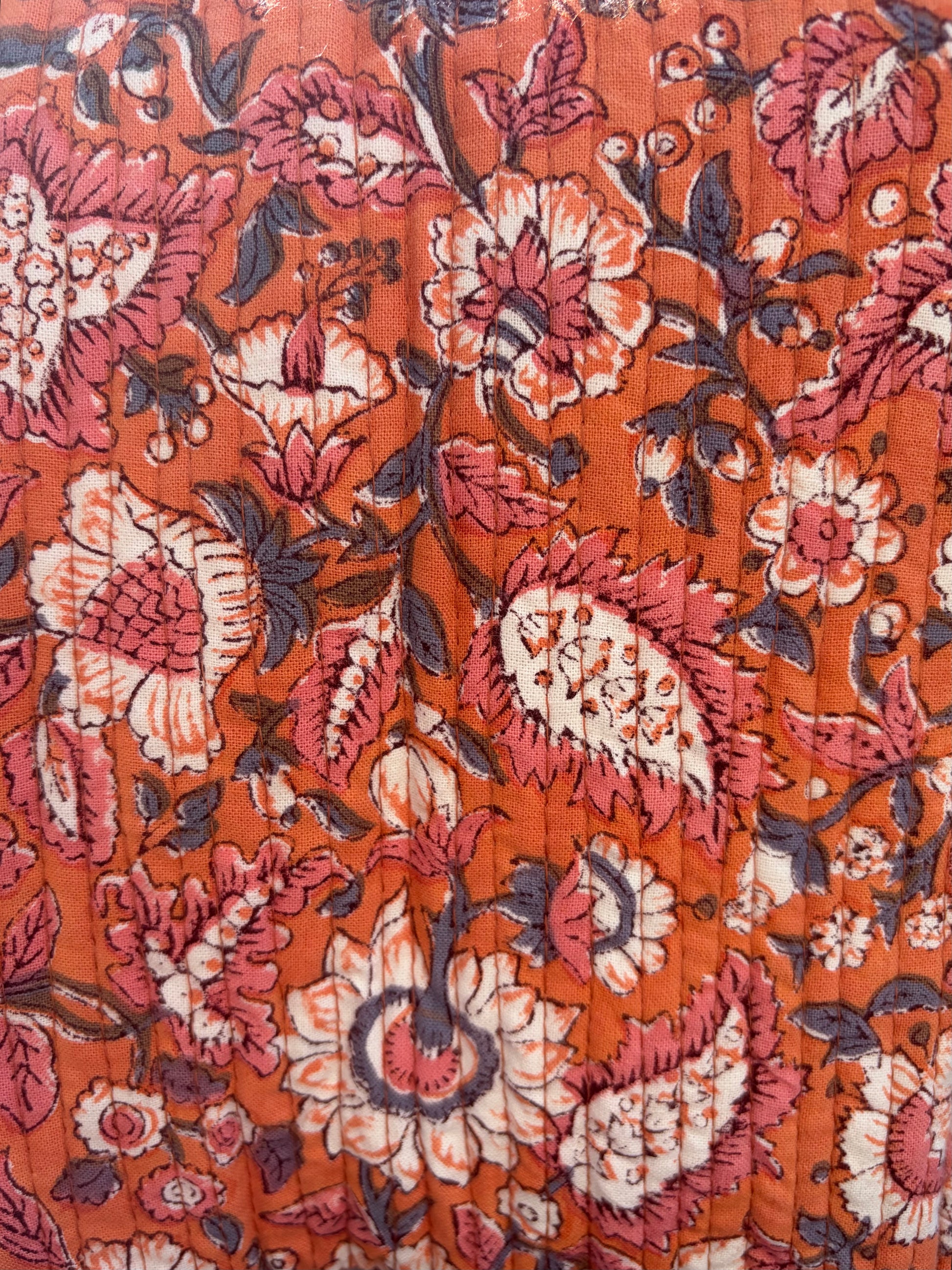 House of Mulmul - Blockprinted Cotton Duffle Bag Weekender Bag. Close-up of a floral patterned fabric with a warm color palette.