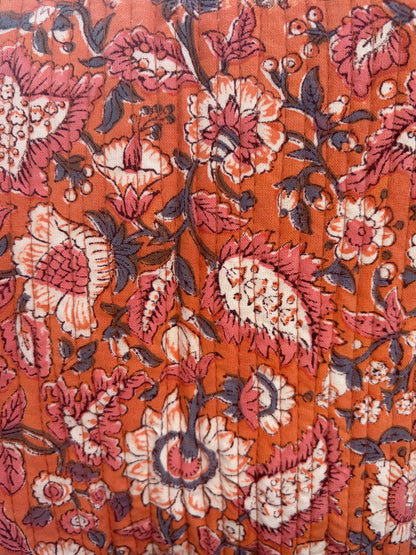 House of Mulmul - Blockprinted Cotton Duffle Bag Weekender Bag. Close-up of a floral patterned fabric with a warm color palette.