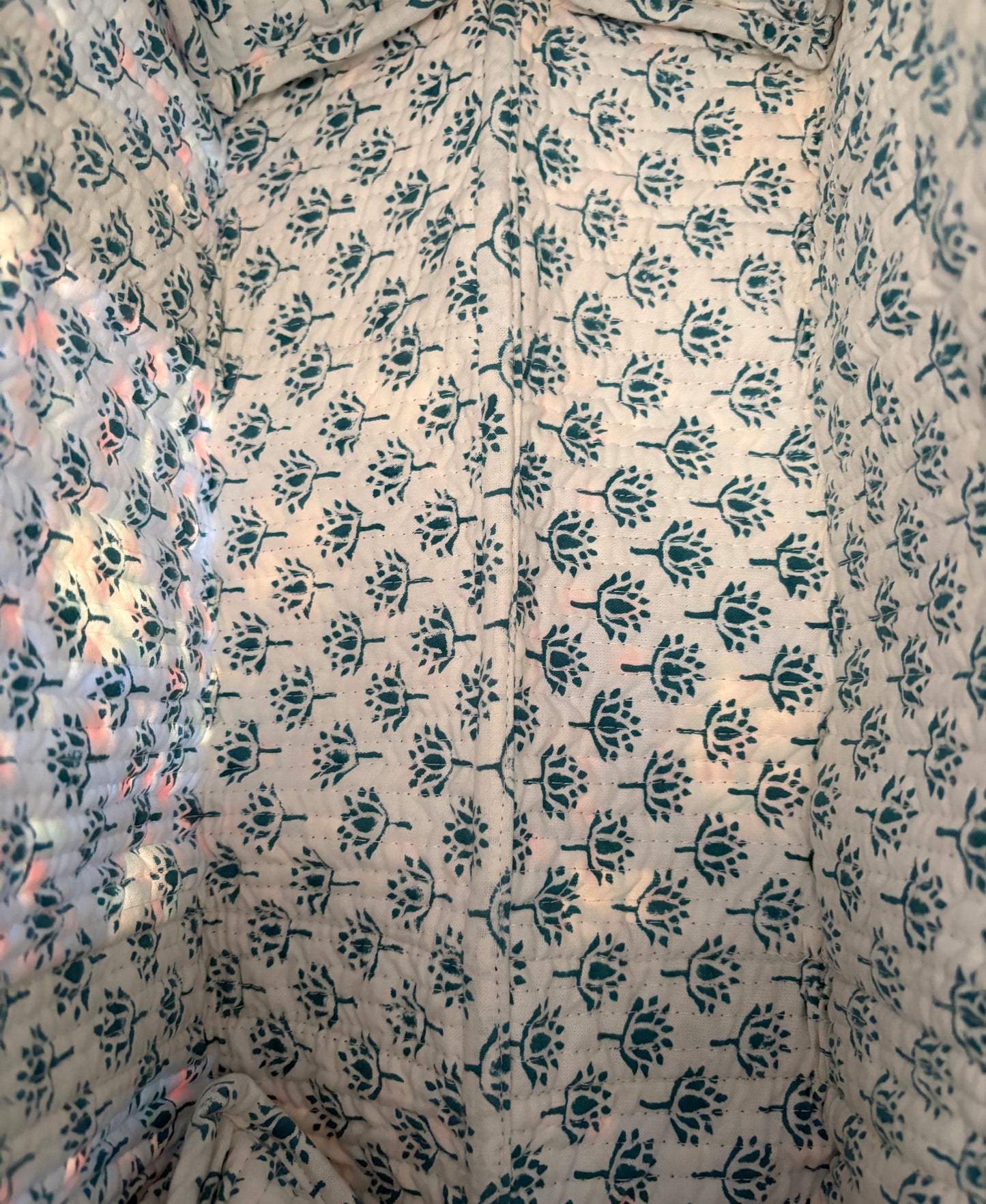 House of Mulmul - Blockprinted Cotton Duffle Bag Weekender Bag. Close-up of fabric with a floral pattern on a beige background