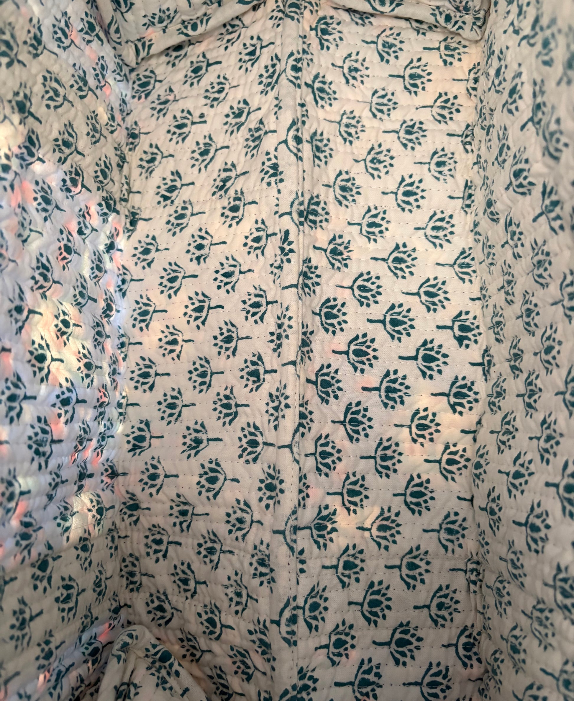 House of Mulmul - Blockprinted Cotton Duffle Bag Weekender Bag. Close-up of fabric with a floral pattern on a beige background