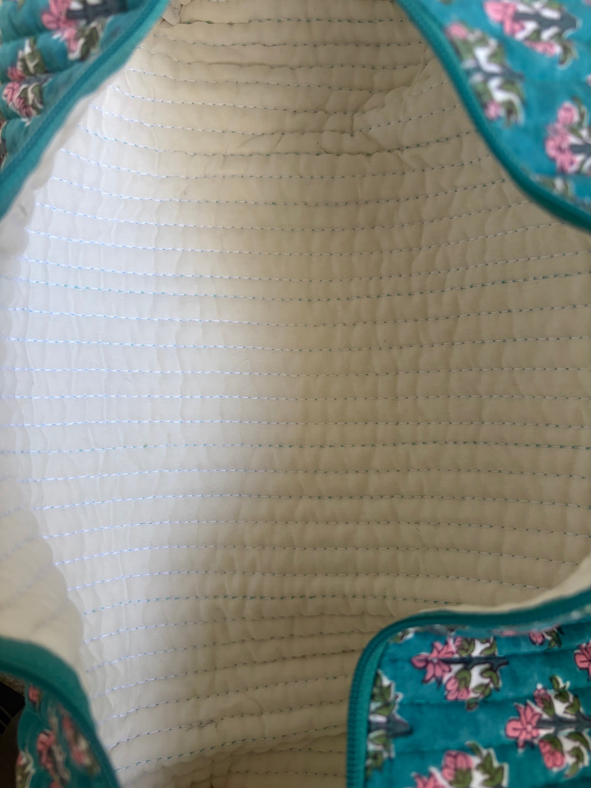 House of Mulmul - Blockprinted Cotton Hair Tool Bag. Close-up of a quilted hair tool bag with floral design on a white background