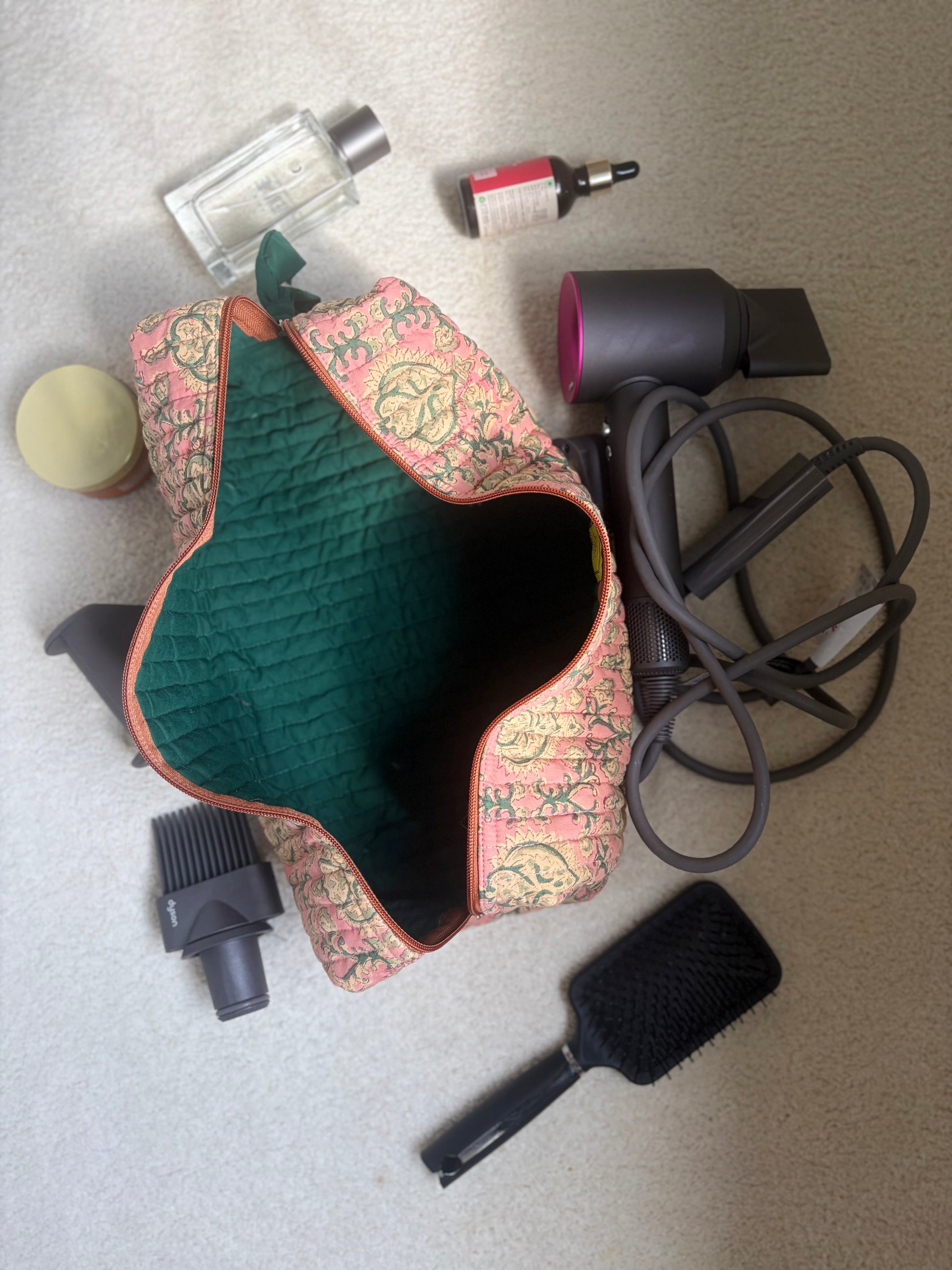 House of Mulmul - Blockprinted Cotton Hair Tool Bag. Dyson hair dryer and straightener kit grooming tools including a hair dryer, brush, and nozzle on a textured surface.