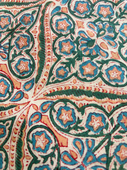 House of Mulmul - Blockprinted Cotton Table Napkins. Close-up of intricate floral pattern with green, blue, and orange colors.