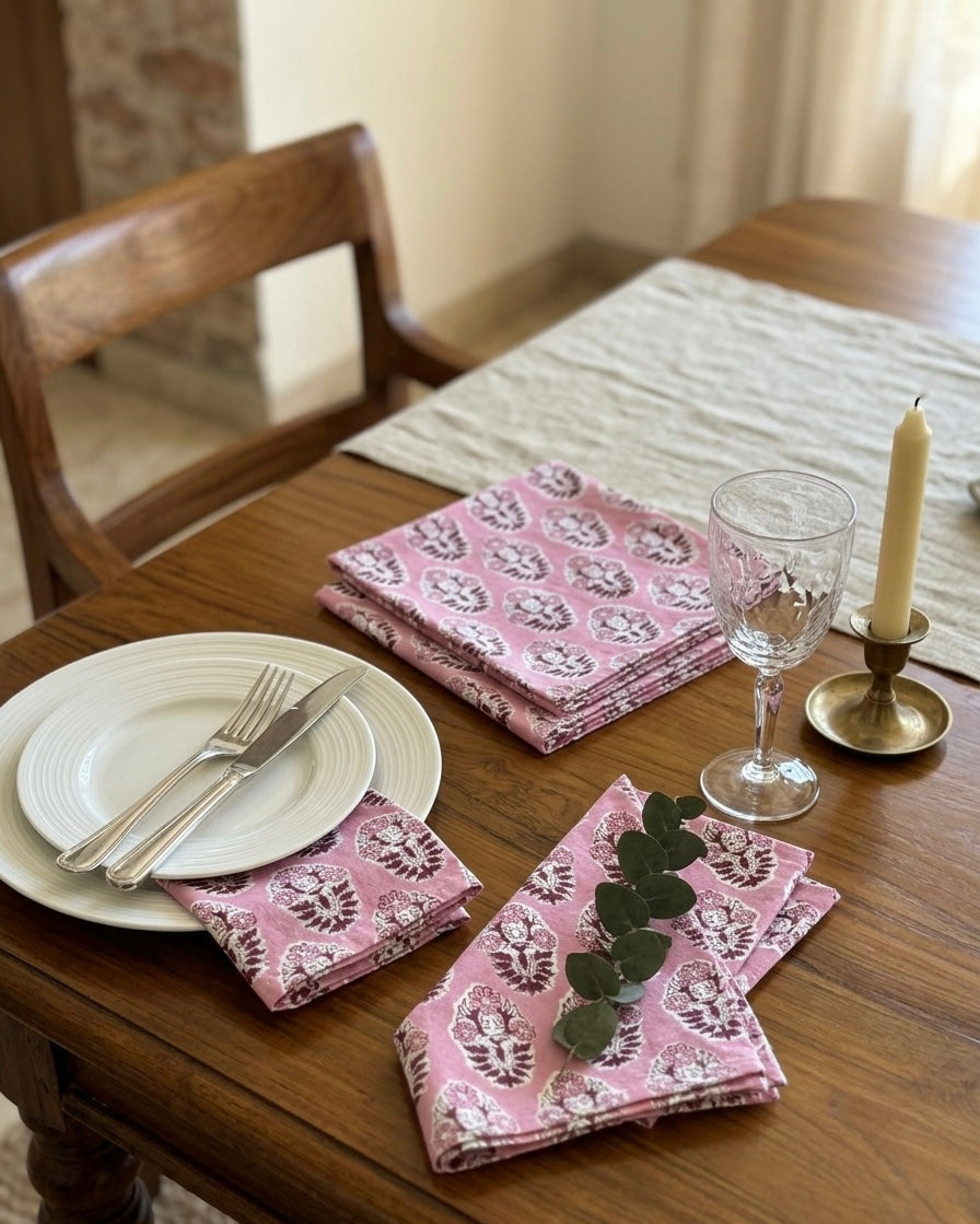 House of Mulmul - Blockprinted Cotton Table Napkins. Dining table set with pink floral cotton napkins, plates, and cutlery.