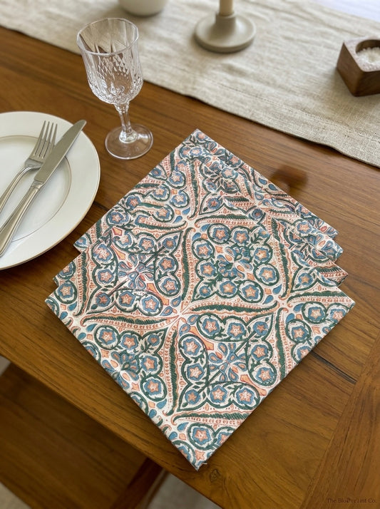 House of Mulmul - Blockprinted Cotton Table Napkins. Patterned napkin on a wooden table with cutlery and glassware.