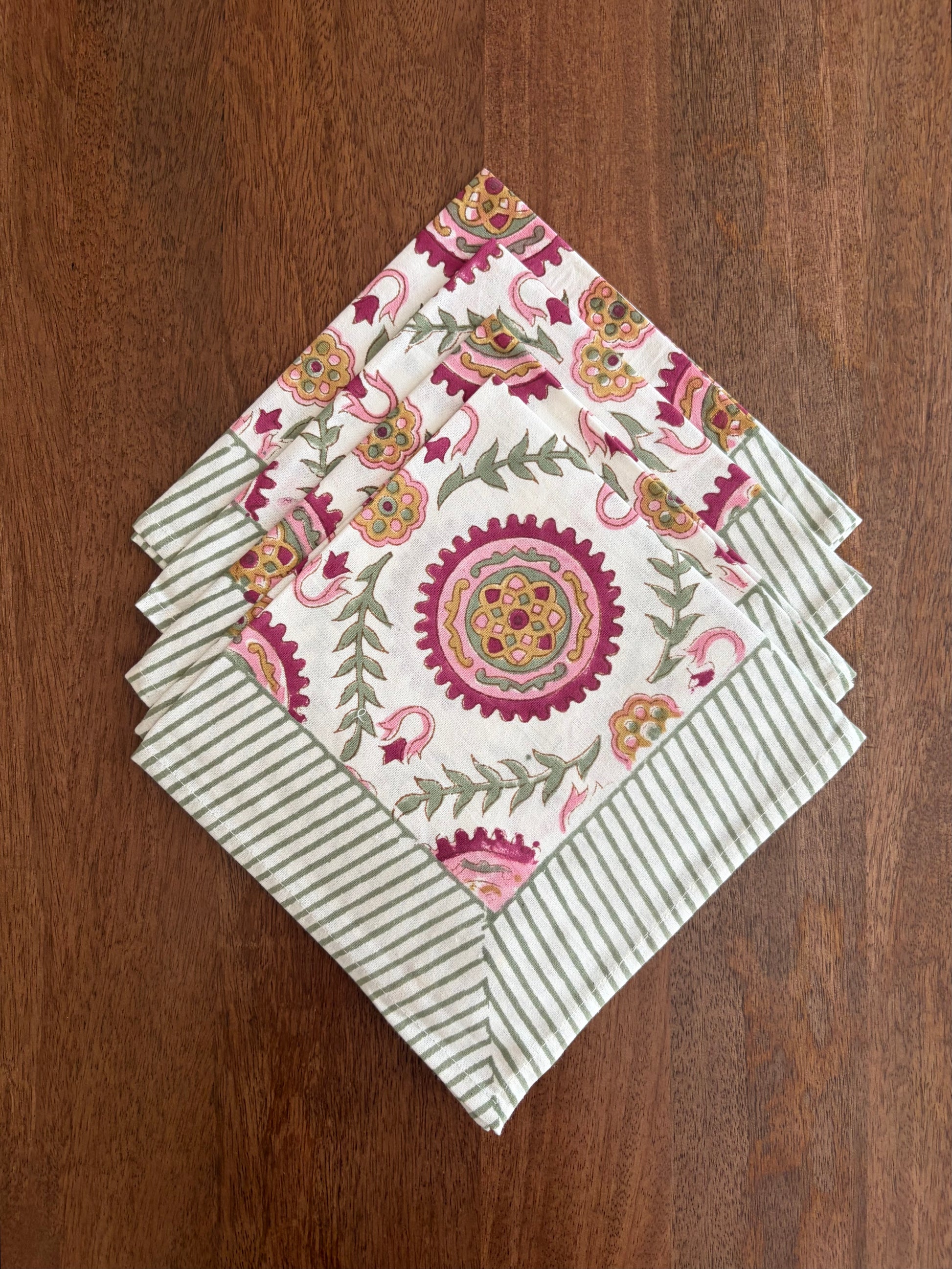 House of Mulmul_ Blockprinted Cotton Napkins. Set of floral and striped napkins on a wooden surface