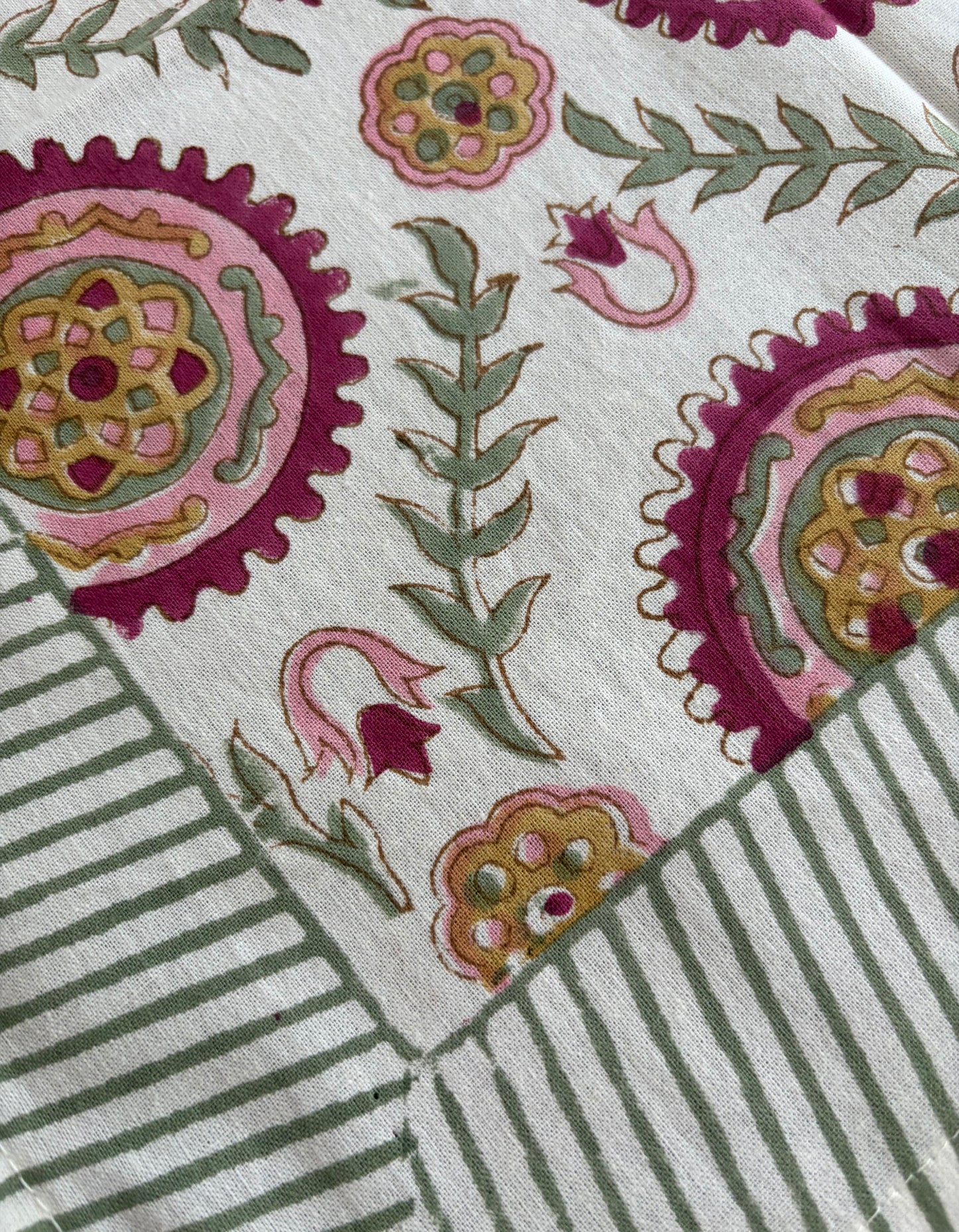 House of Mulmul_ Blockprinted Cotton Napkins. Close-up of a fabric with floral and striped patterns on a white background