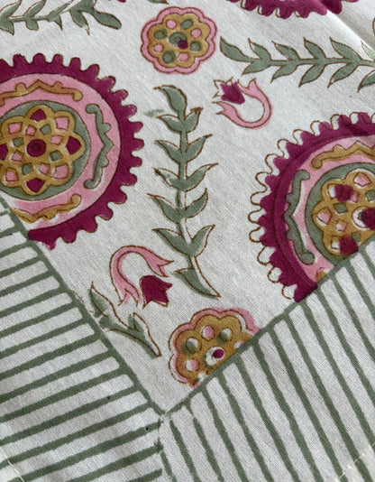 House of Mulmul_ Blockprinted Cotton Napkins. Close-up of a fabric with floral and striped patterns on a white background