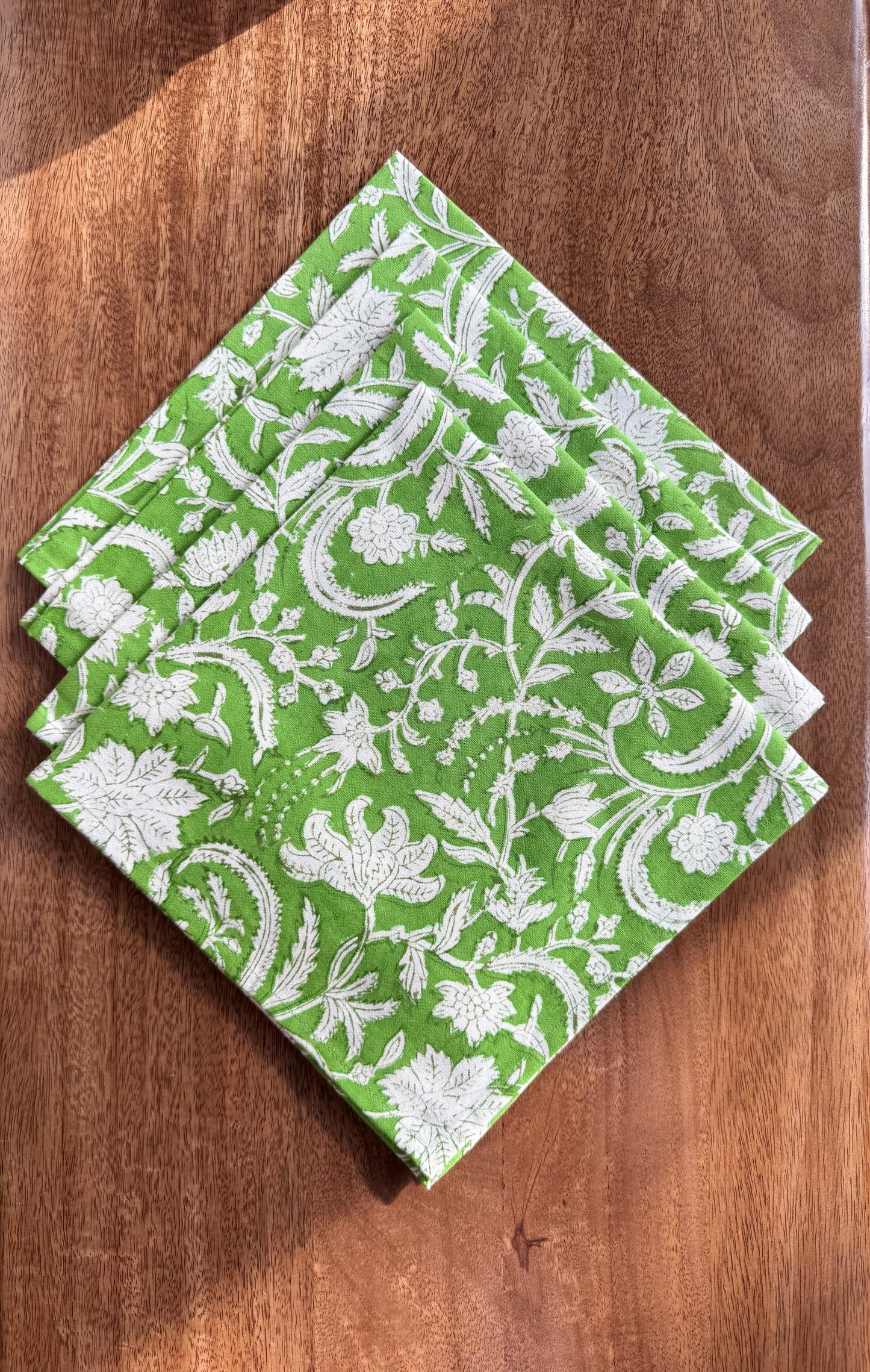 House of Mulmul - Blockprinted Cotton Napkins. Green and white patterned napkins on a wooden surface