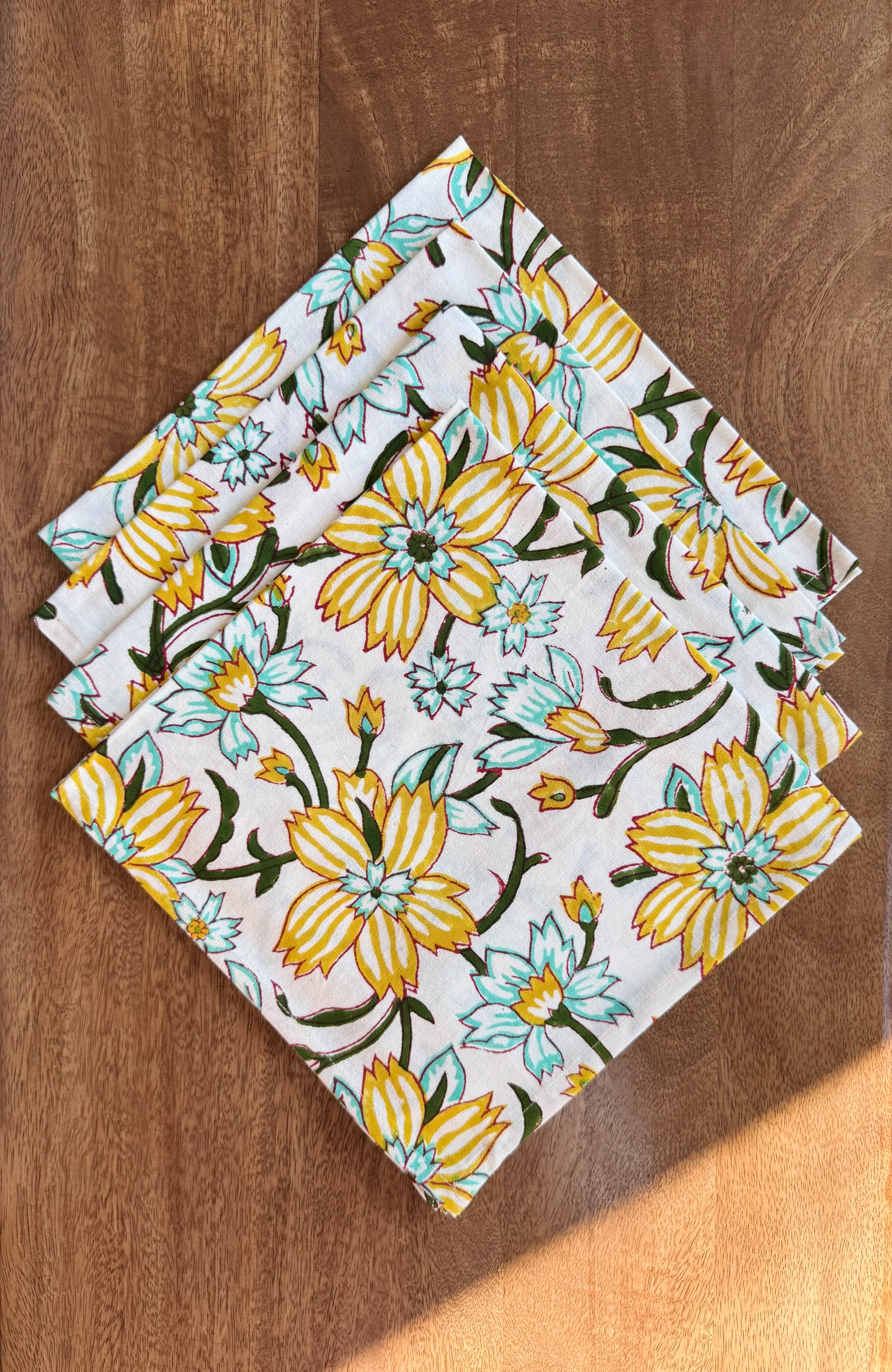 House of Mulmul - Blockprinted Cotton Napkins. Floral-patterned napkins on a wooden surface