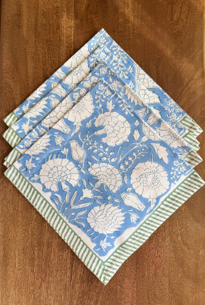 House of Mulmul - Blockprinted Cotton Napkins. Set of floral-patterned napkins with green stripes on a wooden surface