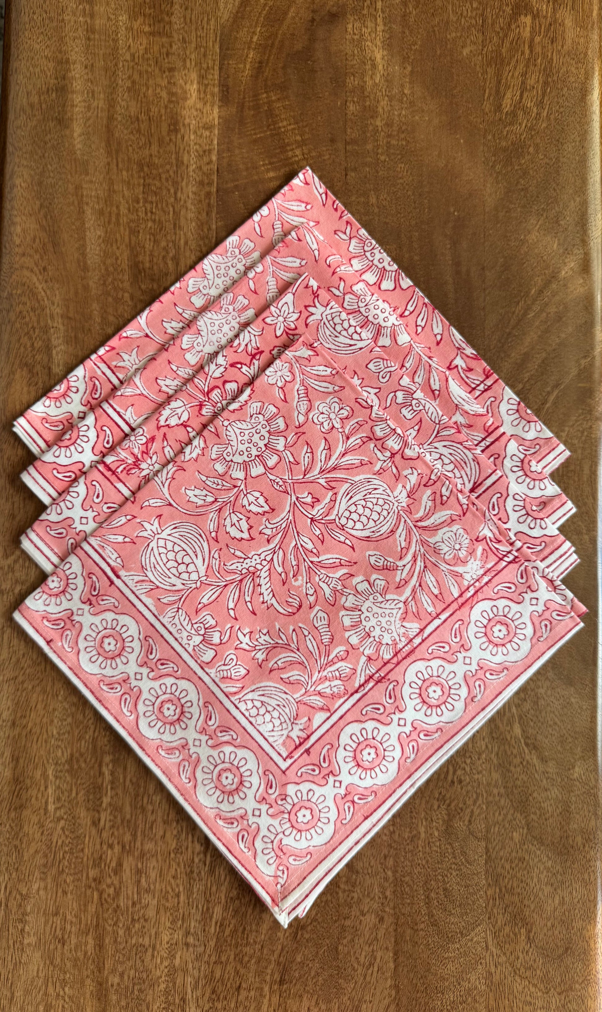 House of Mulmul - Blockprinted Cotton Napkins. Set of pink patterned napkins on a wooden surface