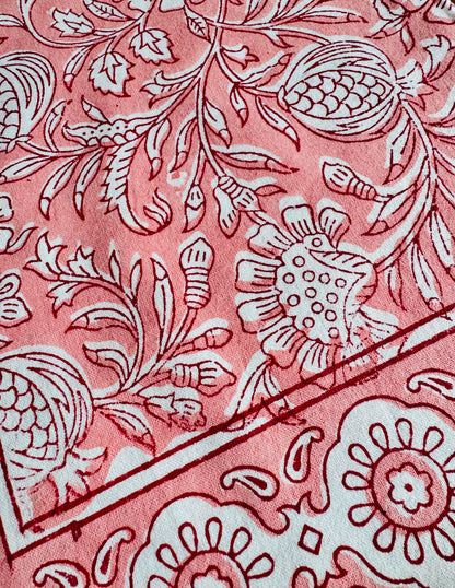 House of Mulmul - Blockprinted Cotton Napkins. Close-up of a pink napkins with white floral and leaf patterns