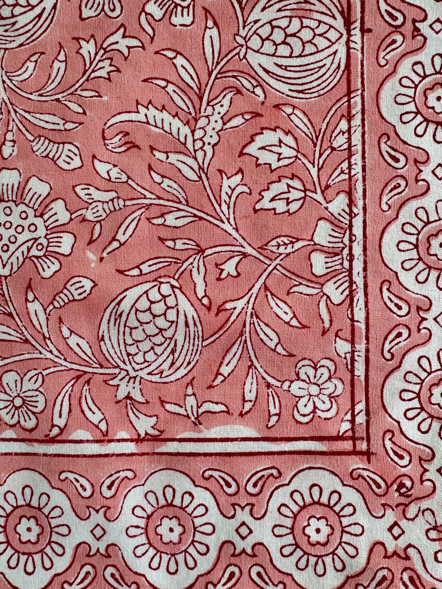 House of Mulmul - Blockprinted Cotton Napkins. Close-up of a pink napkins with white floral and leaf patterns