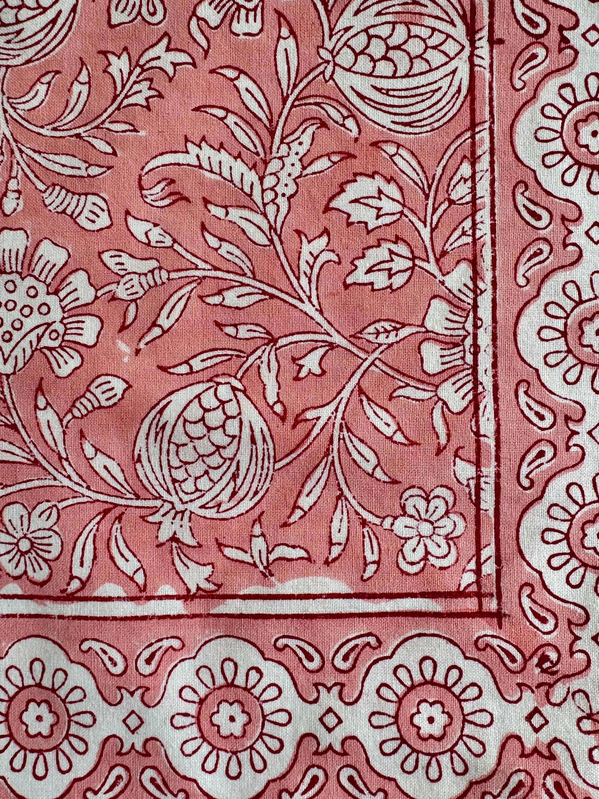 House of Mulmul - Blockprinted Cotton Napkins. Close-up of a pink napkins with white floral and leaf patterns