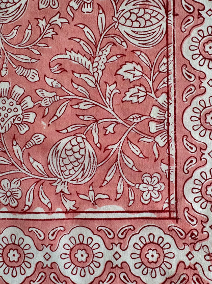 House of Mulmul - Blockprinted Cotton Napkins. Close-up of a pink napkins with white floral and leaf patterns
