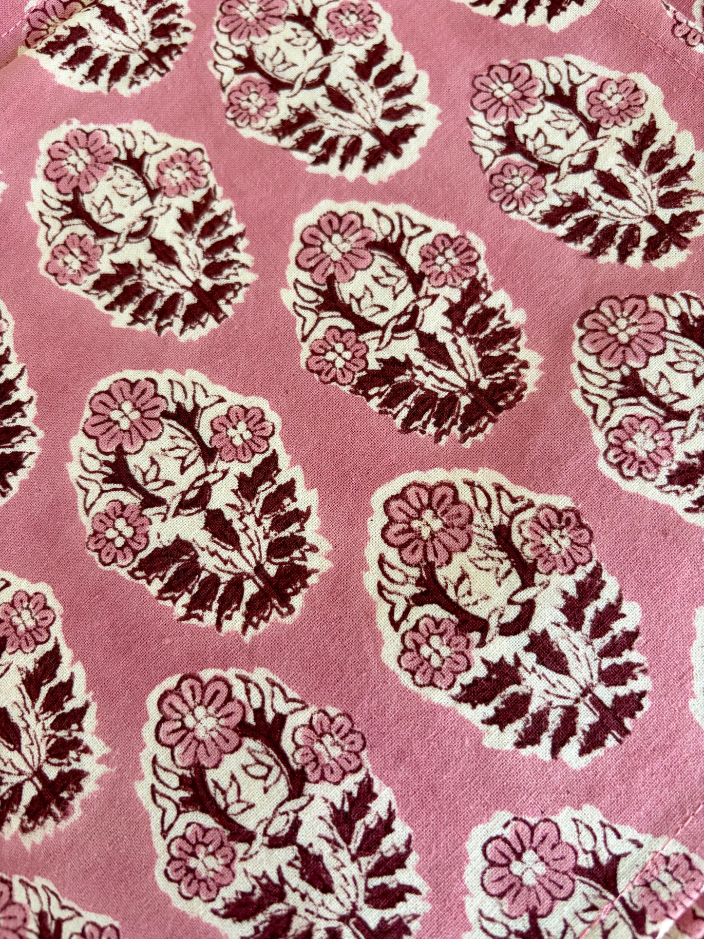 House of Mulmul - Blockprinted Cotton Table Napkins. Pattern of floral and leaf designs on a pink background