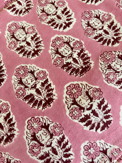 House of Mulmul - Blockprinted Cotton Table Napkins. Pattern of floral and leaf designs on a pink background