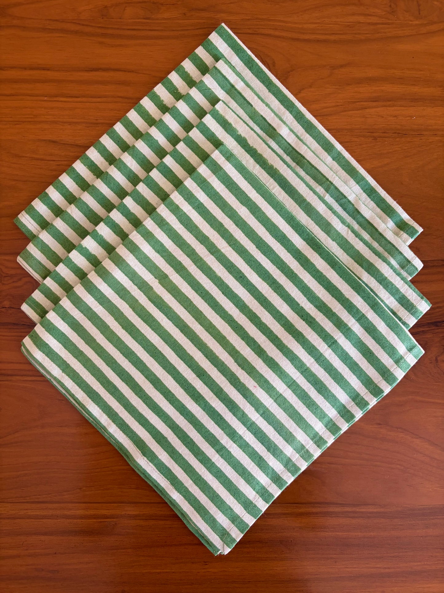 House of Mulmul - Blockprinted Cotton Table Napkins. Green and white striped table napkins on a wooden surface